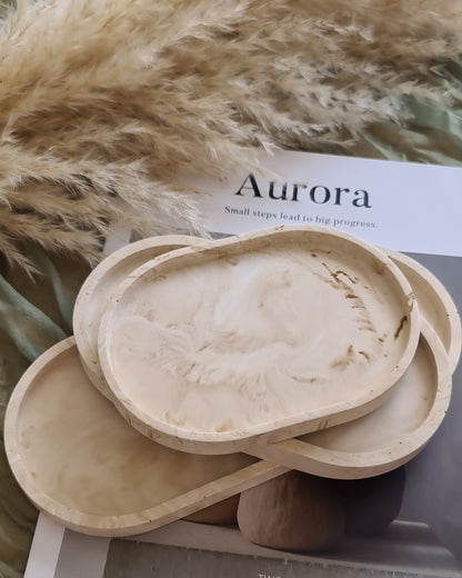 Ryssa Trays in three sizes on book titled 'Aurora', with pampas, in natural light.