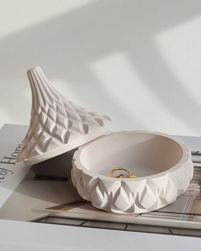 Book titled 'The Art of Home' with a decorative lidded jar on a white background