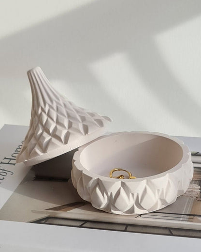 Book titled 'The Art of Home' with a decorative lidded jar on a white background