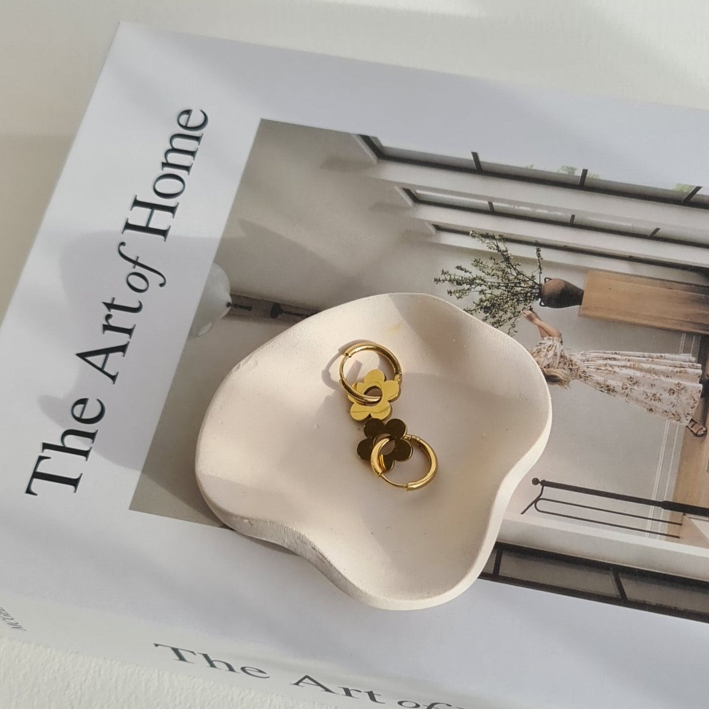 Petal dish in natural lighting, on a book called 'The Art of Home'