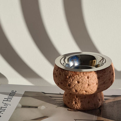 Manzil bukhoor burner on a book titled 'The Art of Home' with a minimal background