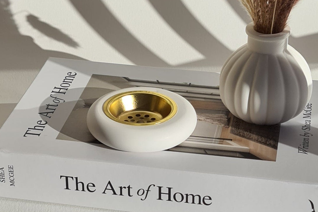 Lifestyle scene with cast-stone burner; gentle incense smoke.