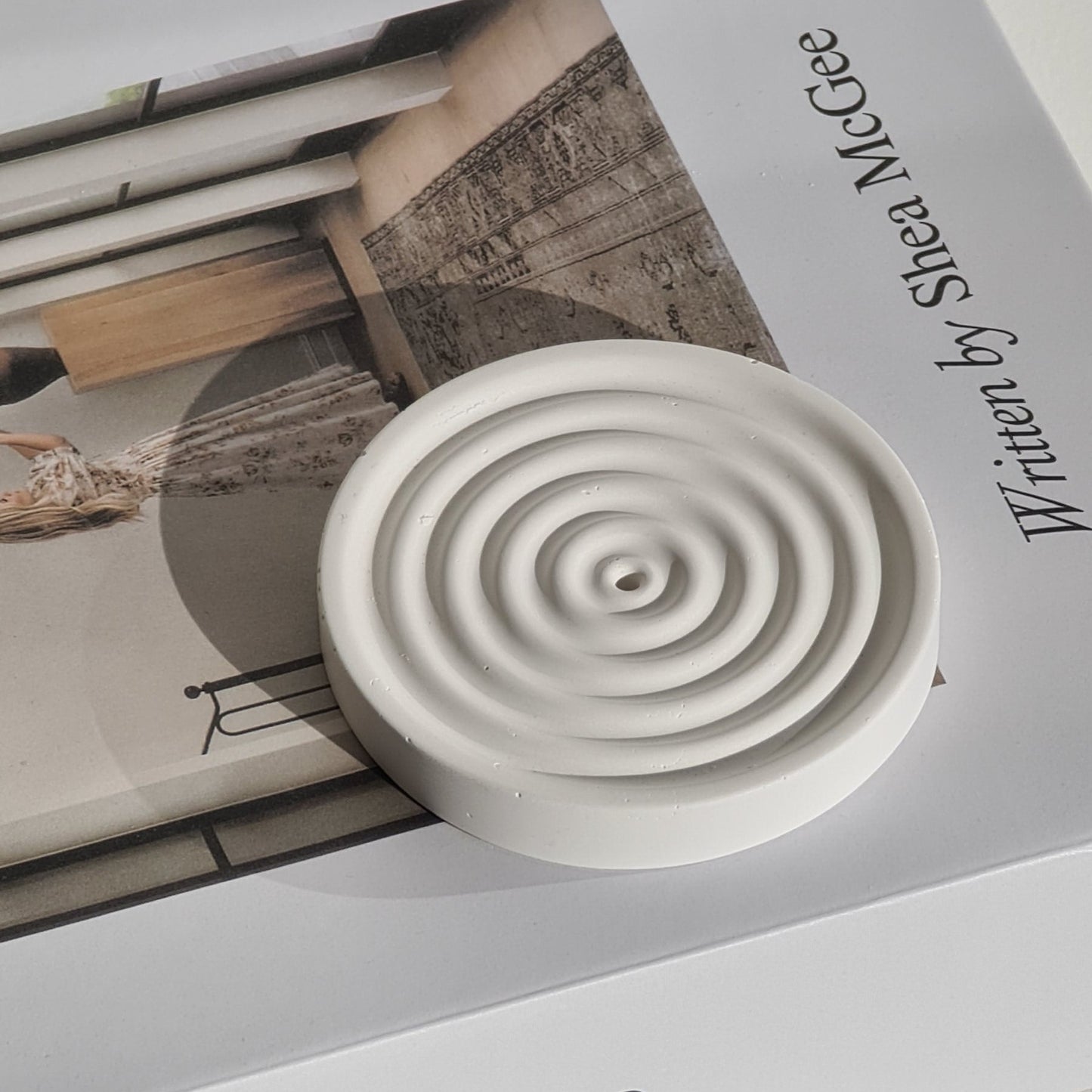 Incense stick holder with spiral design on a magazine titled 'Art of Home'.