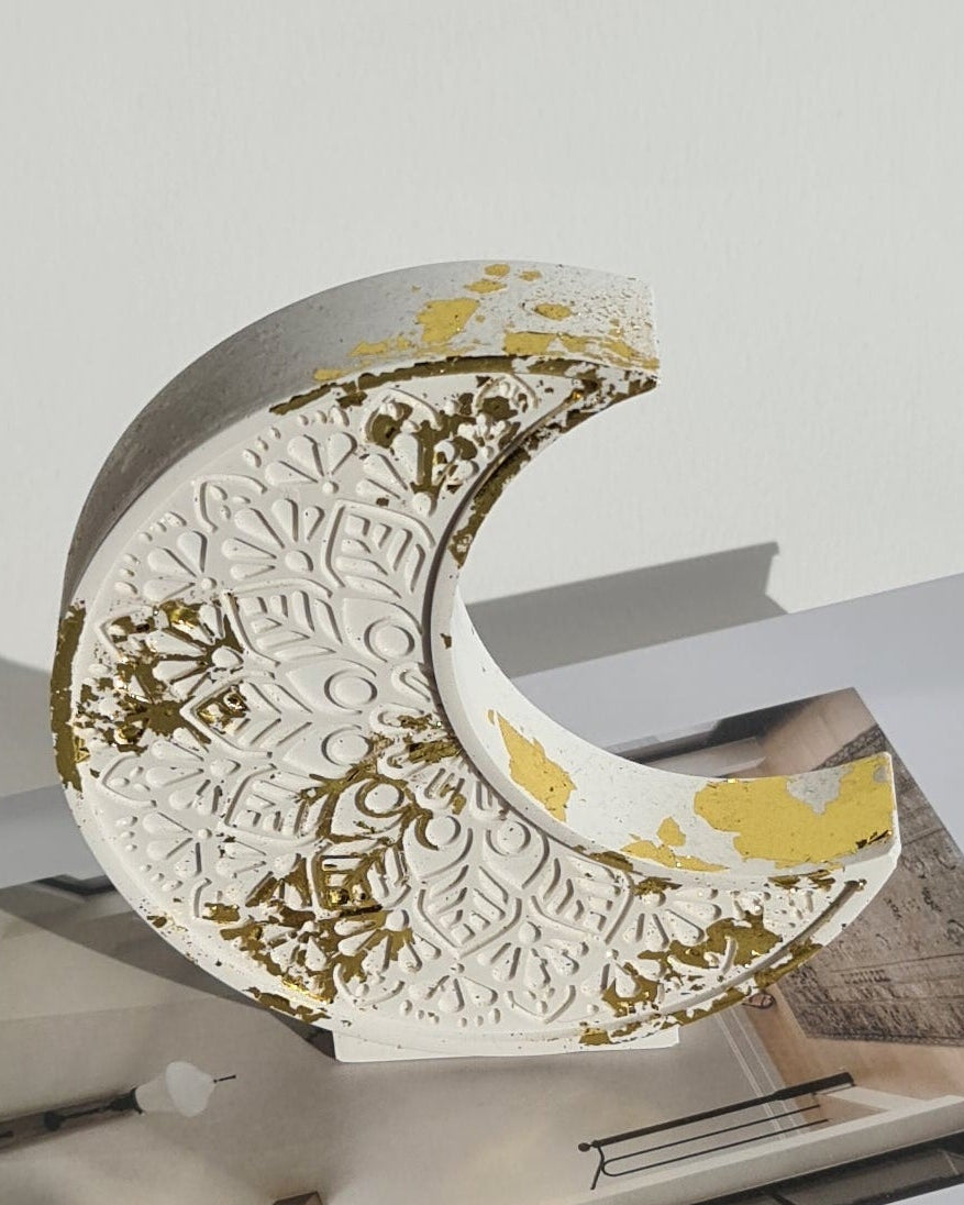 Decorative crescent moon ornament with gold patterns on a magazine
