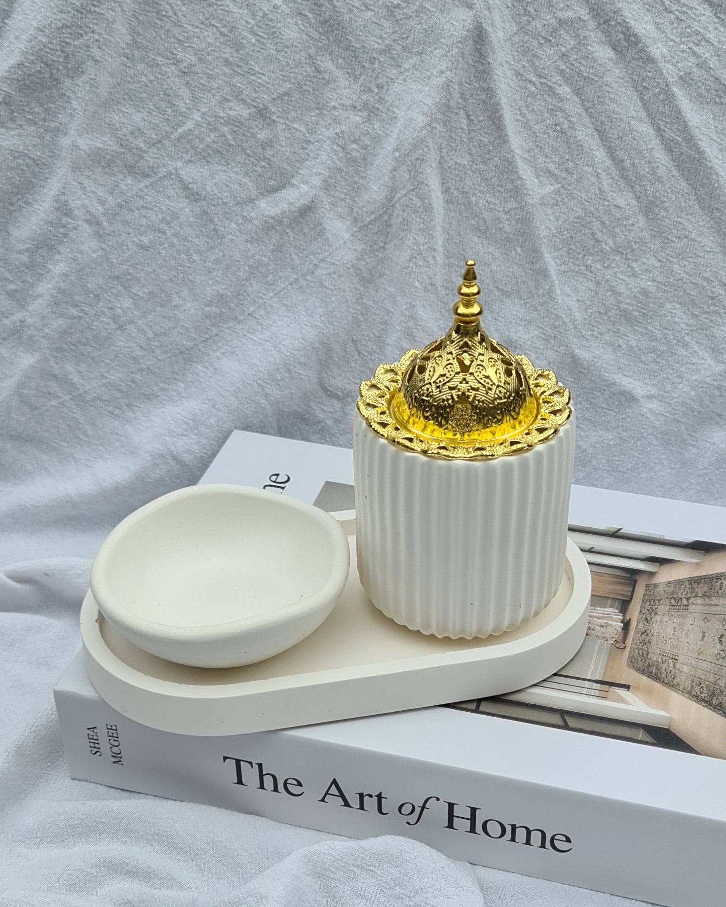 Raayah Set — hand-cast incense burner with gold lid and small matching dish, styled on The Art of Home book.
