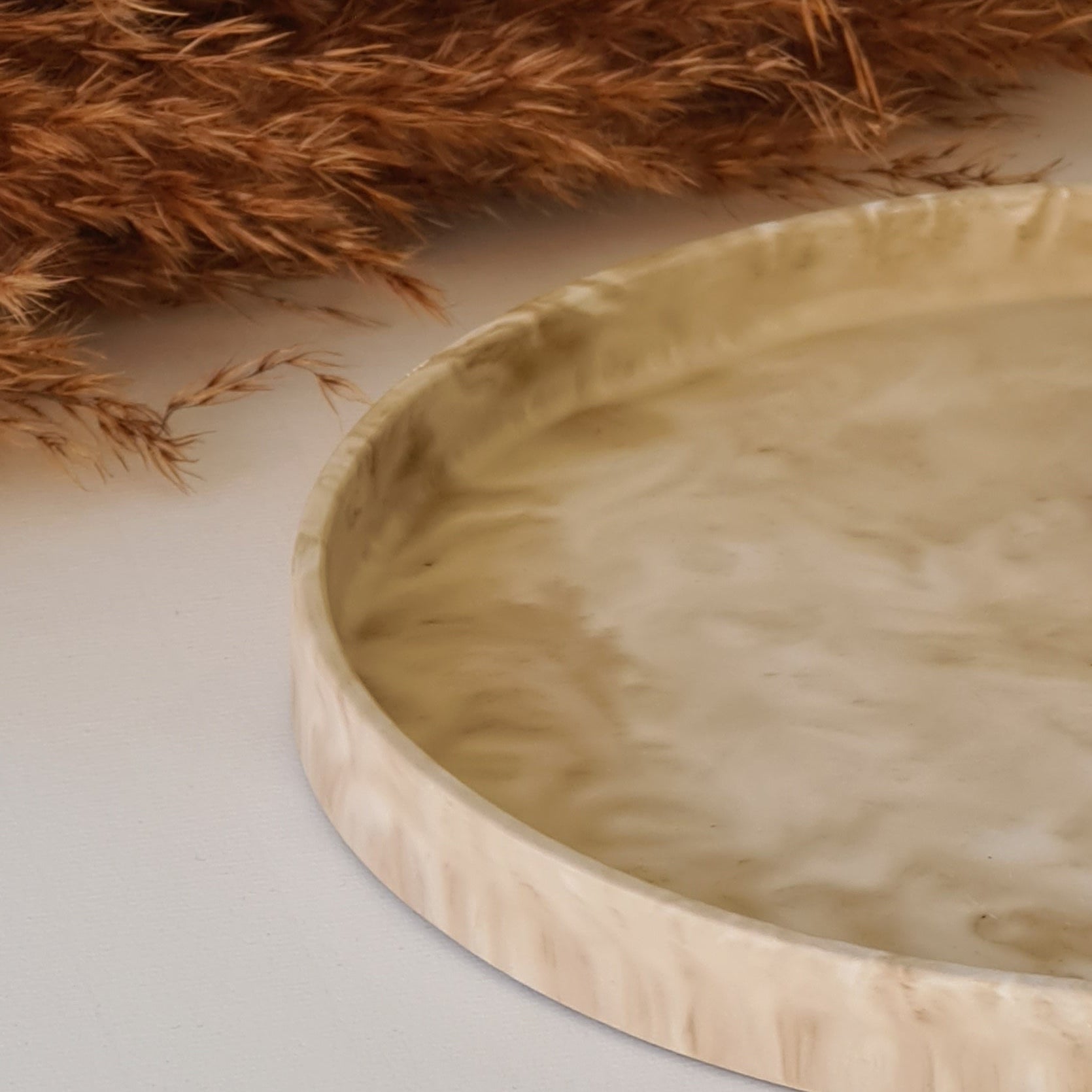 Marbled tray with dried pampas grass on a light background