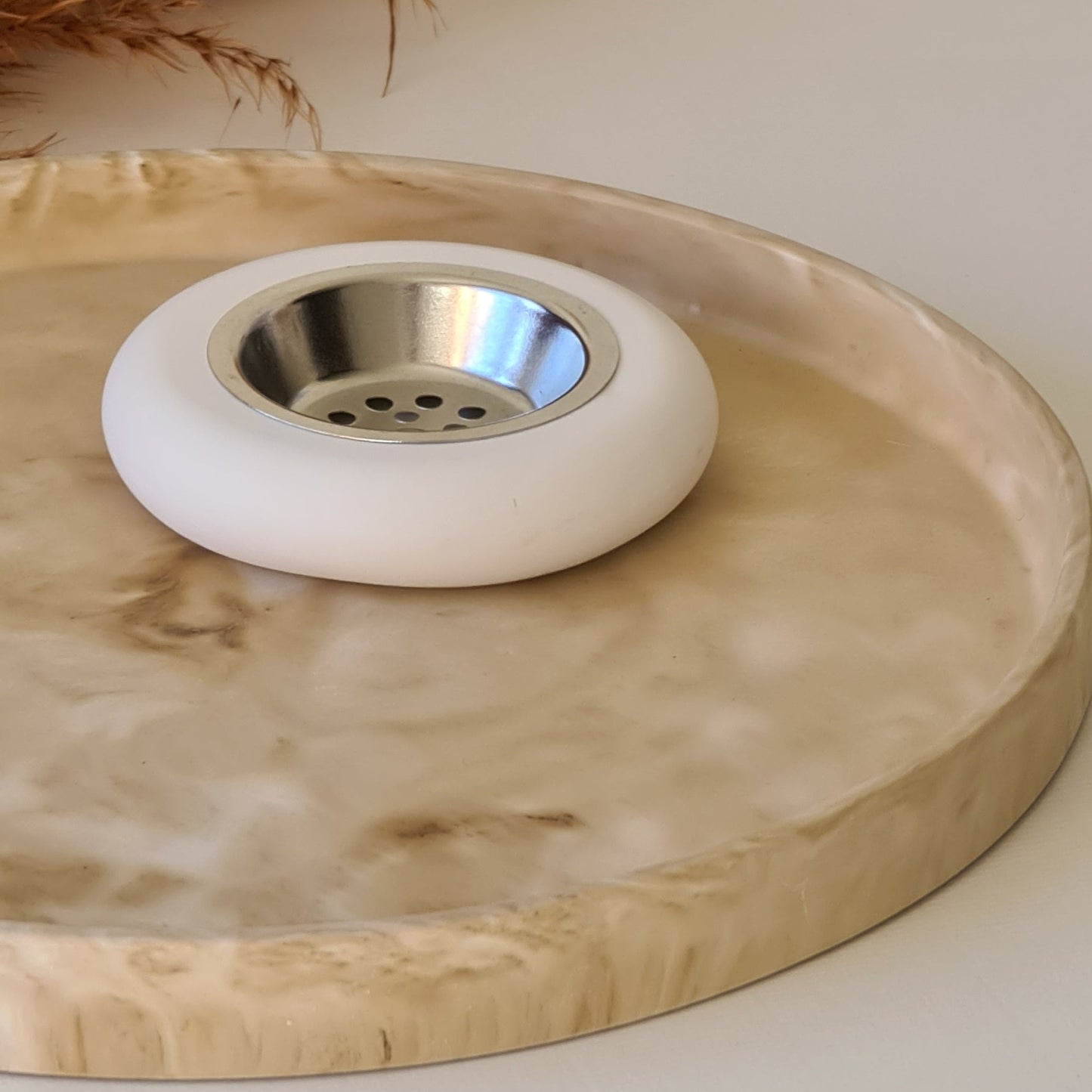 Close-up of a decorative tray with a circular bukhoor burner and white background.