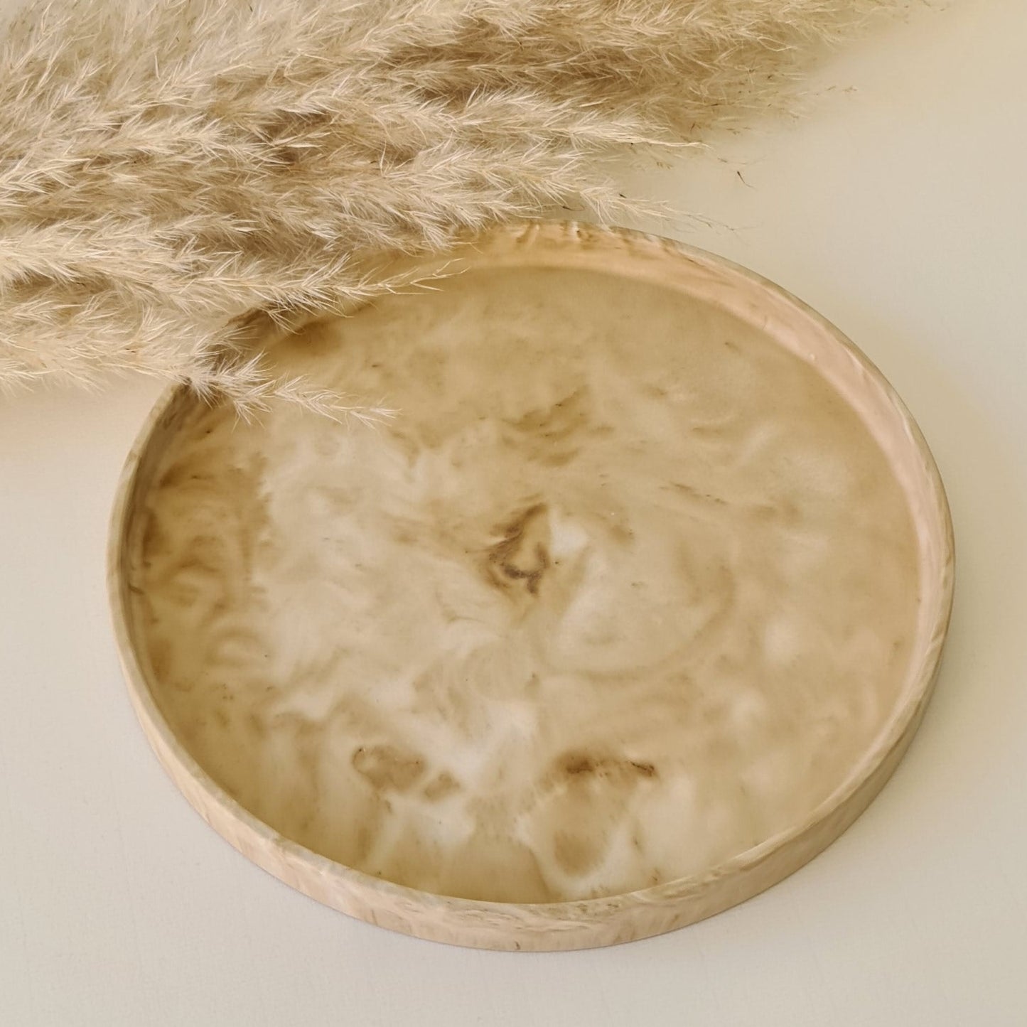 Large decorative tray on a white surface with pampas