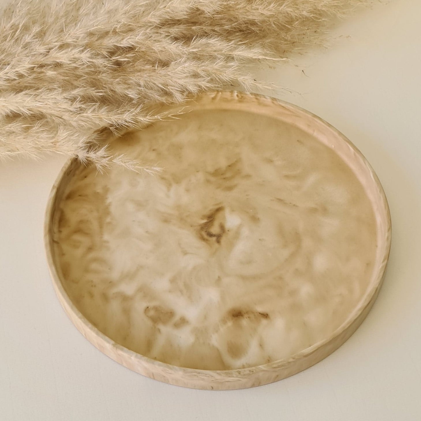 Large decorative tray on a white surface with pampas