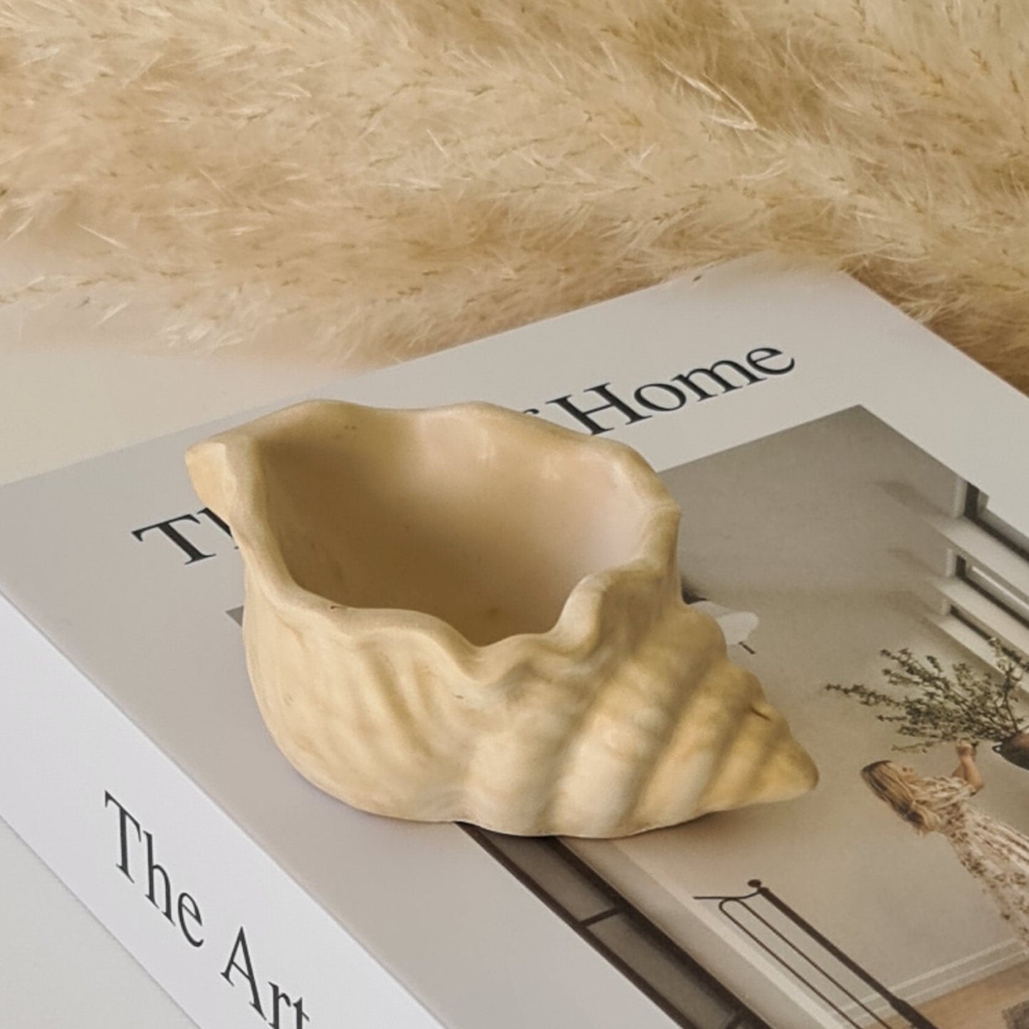 Decorative shell dish on a surface with 'The Art of Home' text