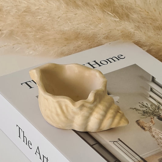 Decorative shell dish on a surface with 'The Art of Home' text