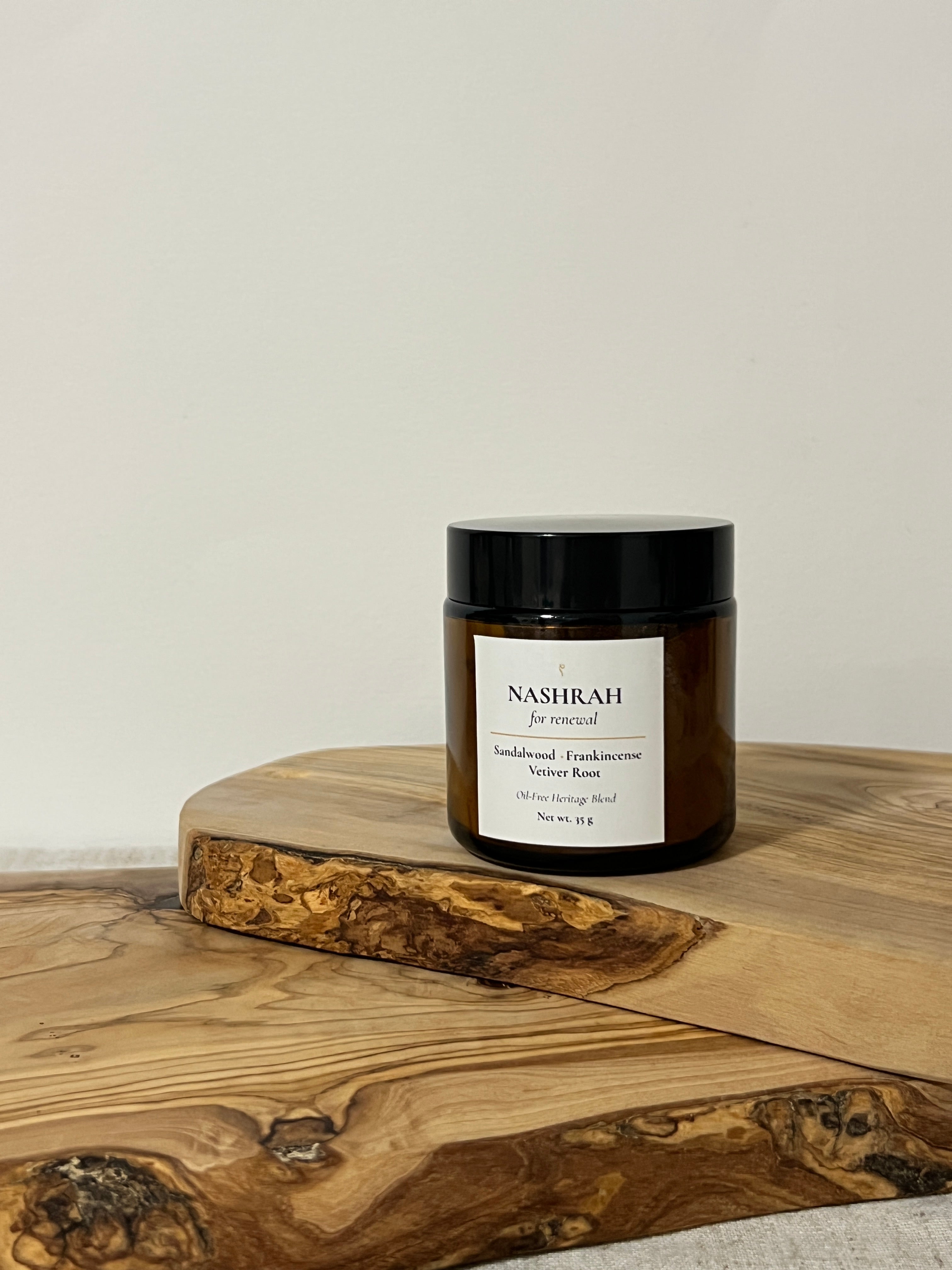 Amber jar f oil-free bukhoor on a wooden board with natural background