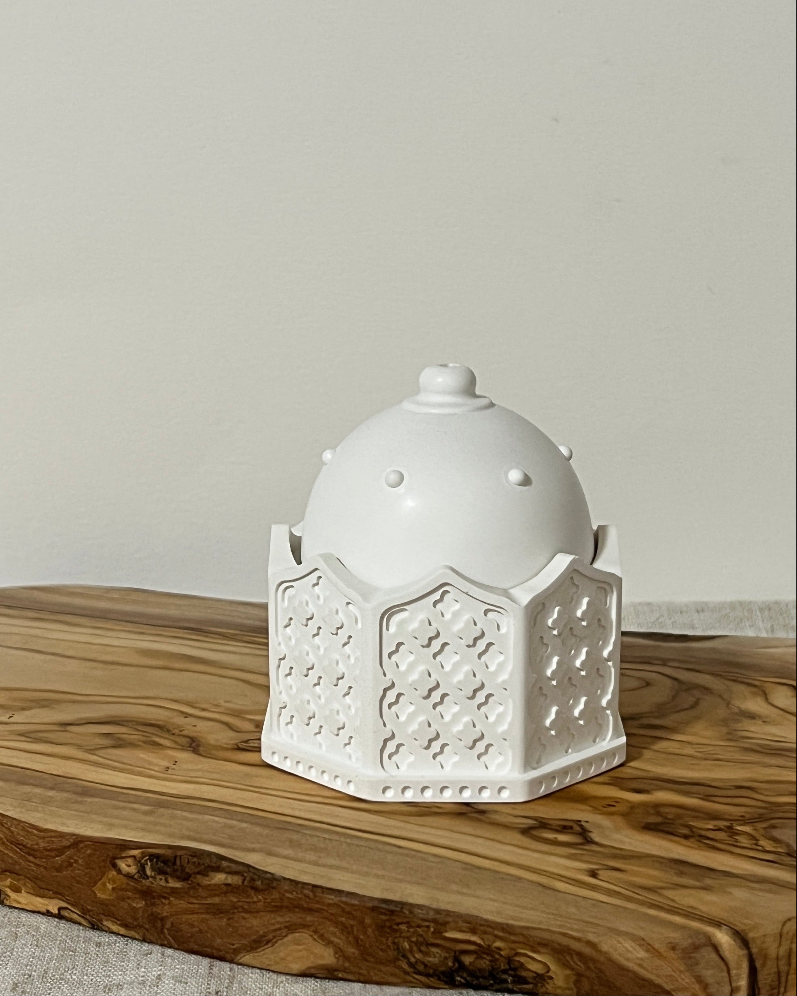White bukhoor burner with dome, in a  geometric design on a wooden board