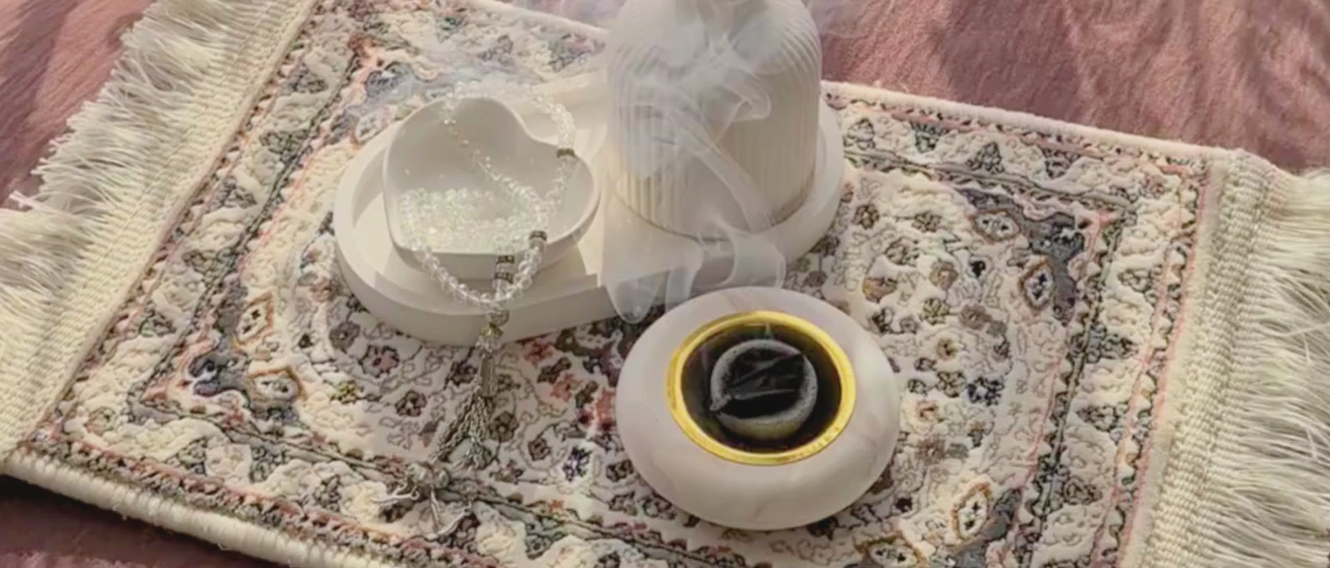 Load video: bukhoor smoke rising from Layali burner on a decorative carpet with a Ryssa tray, Safaa vase and Hubb dish close by